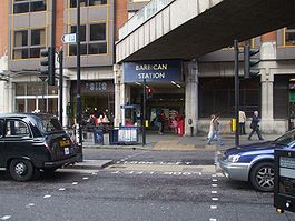 tiny station-entrance tucked under modern bridge