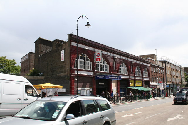 medium-sized maroon-painted station-entrance, formed as a series of five arches