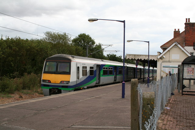 small rural train-station with electric train pulled up