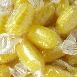 photo of oval yellow boiled sweets wrapped in twists of clear plastic