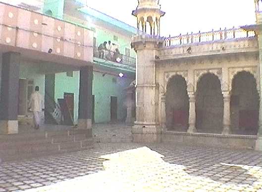 Left half of front of temple, and jumble of buildings beyond it