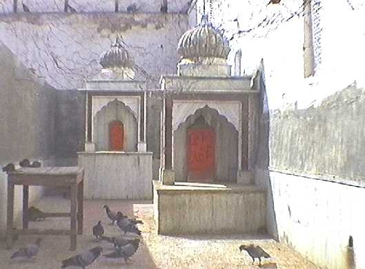 Two small, cupboard-like stone shrines containing carved red tablets