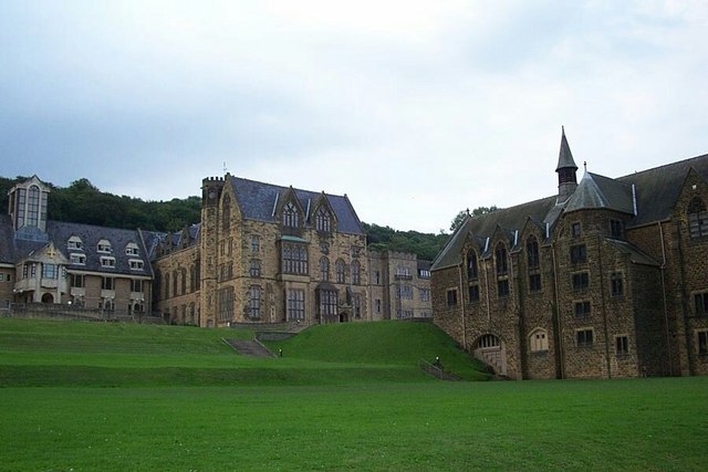 series of tall Victorian buildings in grey-brown brick, staggered down a grassy slope so that the farther-away buildings are progressively higher up than the nearer ones