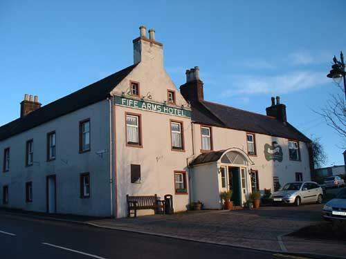 large white eighteenth century building in two wings, having a long porch with a curved roof to it