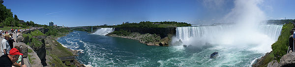 wide panoramic view of two waterfalls with a stretch of dry cliff in between