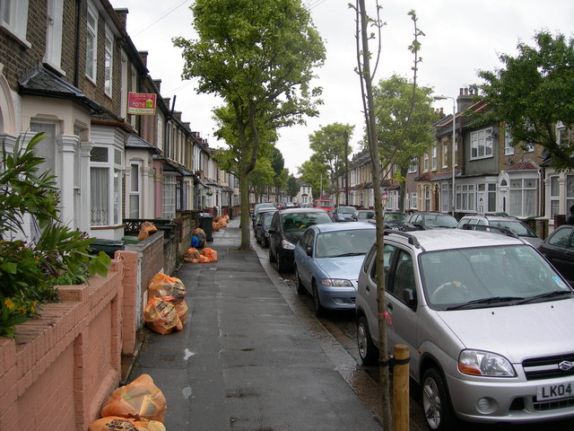 street of two-storey brown-brick houses with bay windows and tiny front gardens about two feet deep