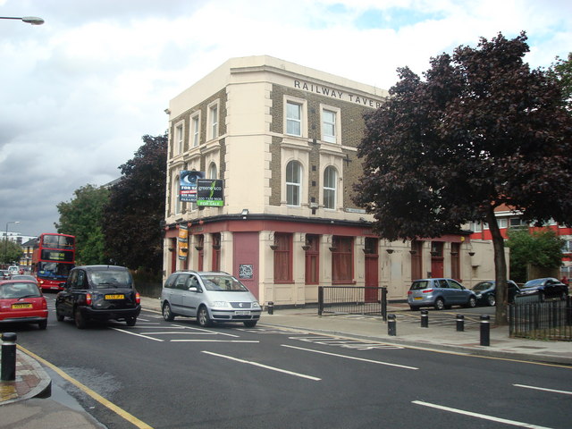 three-storey Victorian pub on a corner, painted cream with taupe and terracotta panels