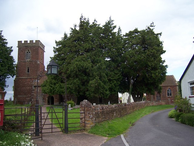 view of small, ancient church and graveyard with yew tree