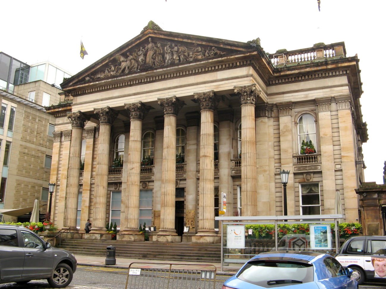 grand cream-coloured building with wide steps up to a facade of two-storey Grecian columns topped by a triangular carved panel