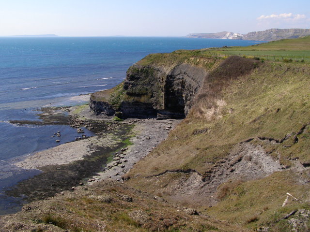 view from top of cliffs down at small bay tucked behind promontory