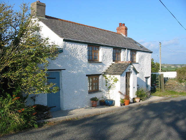 long two-storey white cottage with enclosed porch and deep-set windows