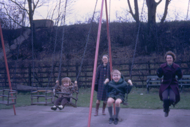 mothers and children playing on basic playground swings