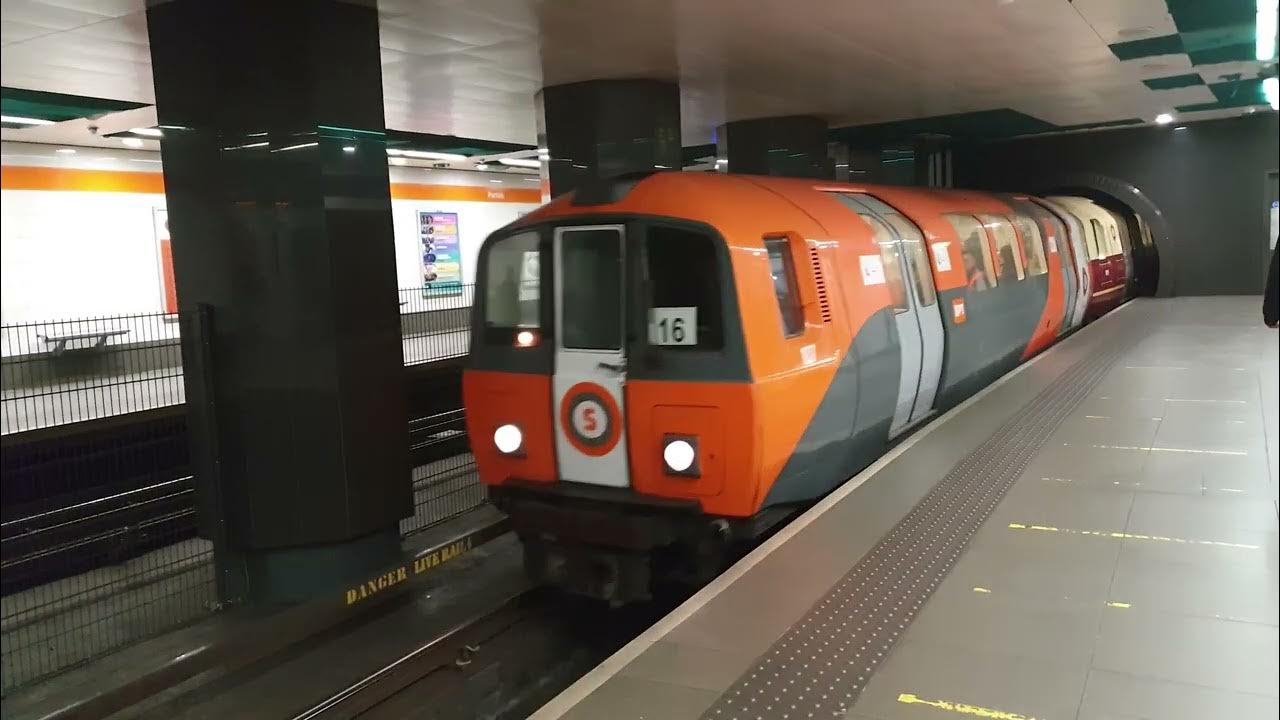 Photo of small orange underground train pulling into station