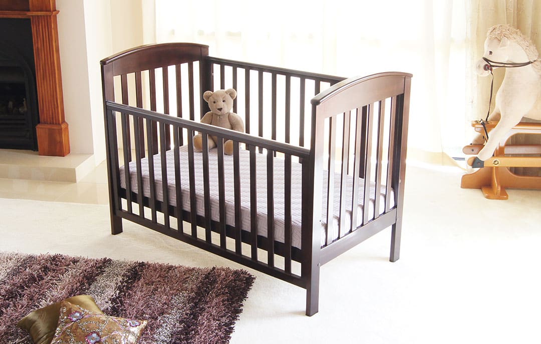 Photo of brown wooden cot with one side lowered
