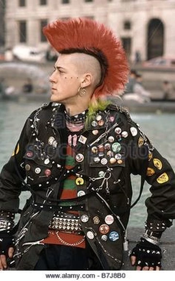 Photo of young man with dark orange Mohican hair and black leather jacket covered in badges