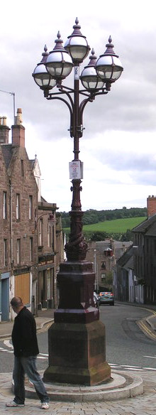 stone plinth supporting an ornate iron pillar topped by five globe lamps