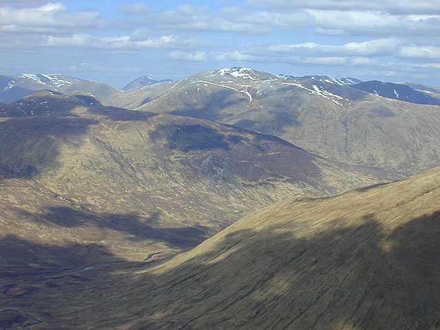 looking from one green range of mountains to the next, with a shadow-dappled valley in between