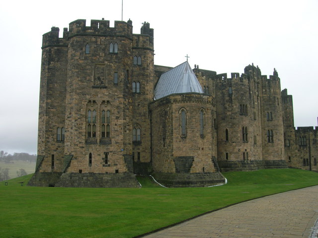 castle consisting of a cluster of dark towers with tall Elizabethan windows