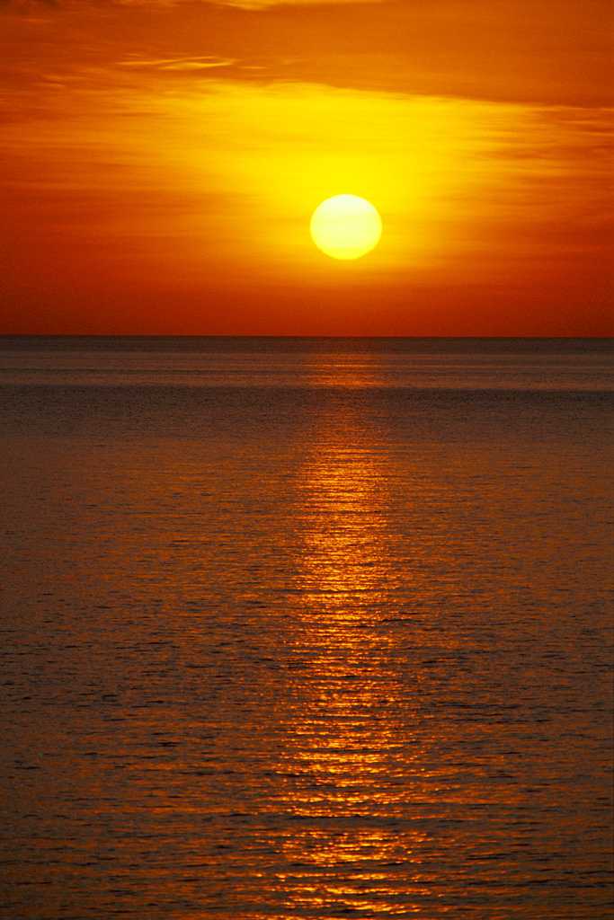 a red sun over the ocean