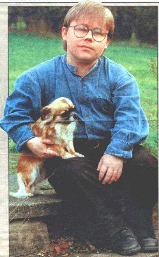 Newspaper photo' of Eric Cullen sitting on garden wall, with long-haired Chihuahua
