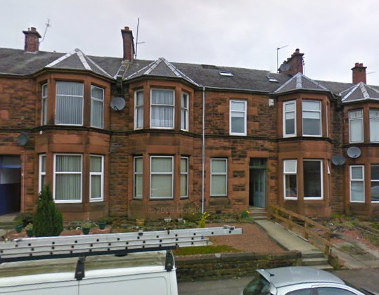 large, brown-stone two-storey Victorian terraced houses with upper and lower bay windows resembling towers the full height of the house, and medium-sized front gardens separated from the pavement by a low wall