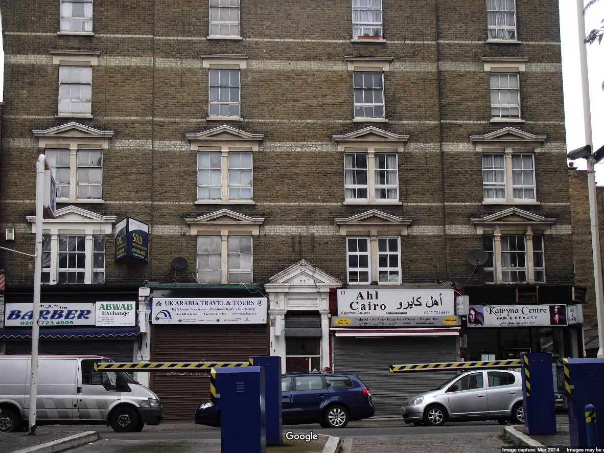 photograph of rather run-down Victorian London tenement above shops