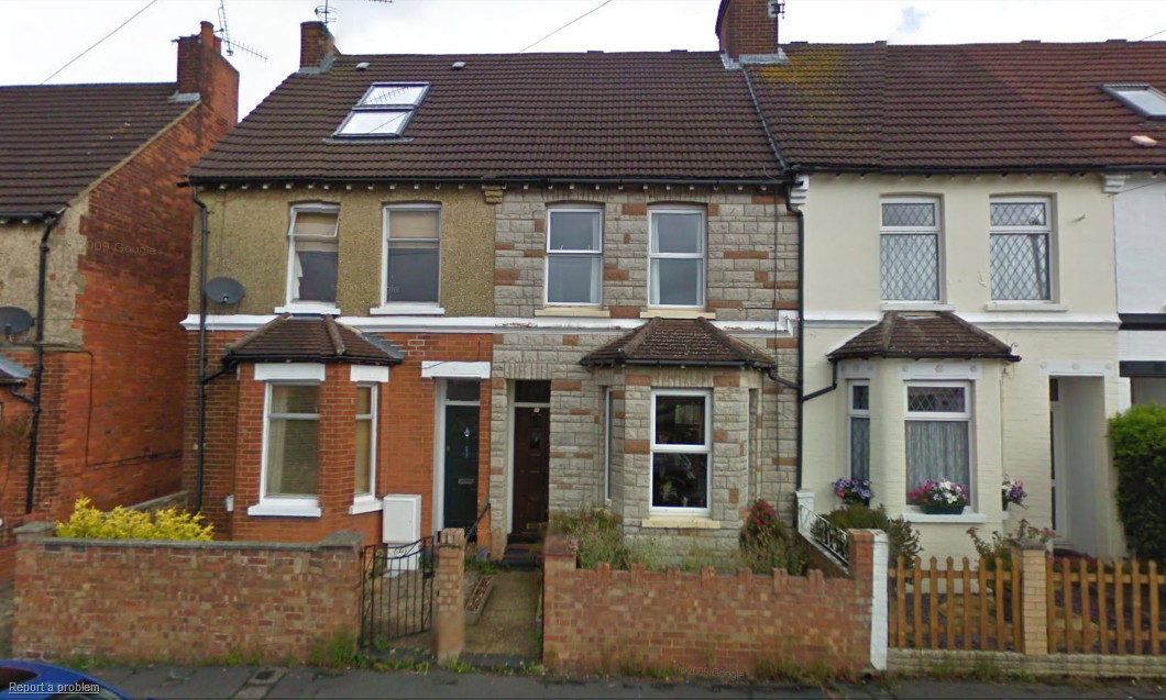 two-storey terraced Victorian houses arranged in pairs, with front gardens and with bay windows on the ground floor: the one on the left is tan brick downstairs and khaki harl upstairs; the one in the middle, with its front door adjacent to the front door of the one on the left, is covered in grey and brown fake stone; and the one on the right is painted cream