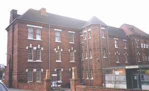 tall institutional-looking building in red brick with white trim