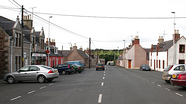 view down a long, straight, rather bleak road fringed with blocky Victorian cottages