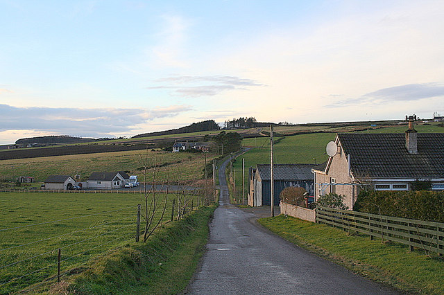 view of road running out across low rolling hills dotted with small houses and farms