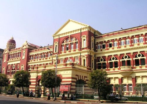 angled view across and along a long ornate grand three-storey Victorian municipal building banded in cream and terracotta