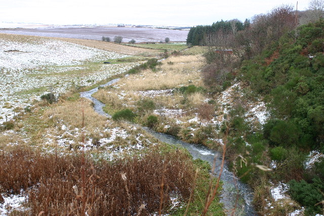 view down a stream winding away through frosty heathland