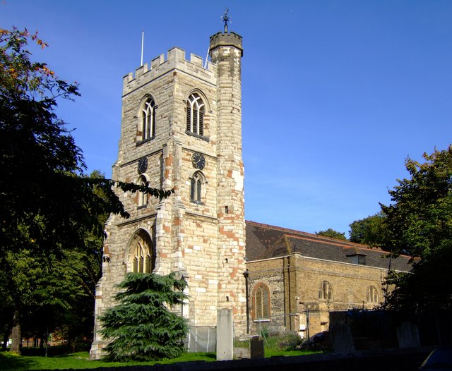 church in pale brick with a high square tower surrounded by trees