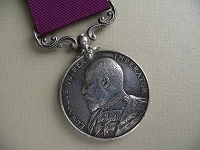 medal showing the head of Edward VII, with plain purple ribbon
