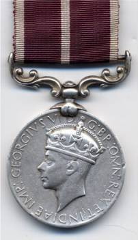 plain round grey medal showing the head of George VI, with a curly, leaf-like bracket at the top, and a maroon ribbon with thin white stripes at either side and down the centre