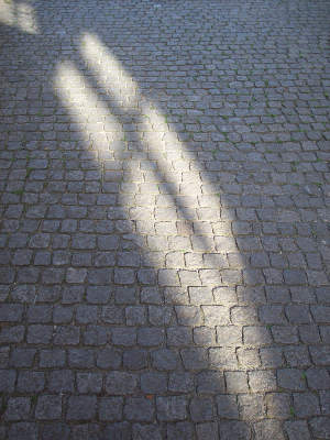 photograph of a shadow on cobbles